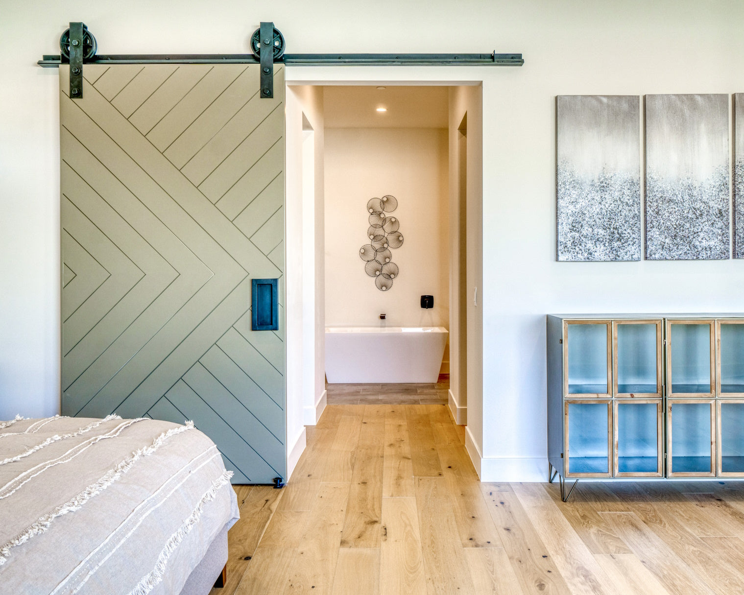 open green barn door leading from bedroom to bathroom